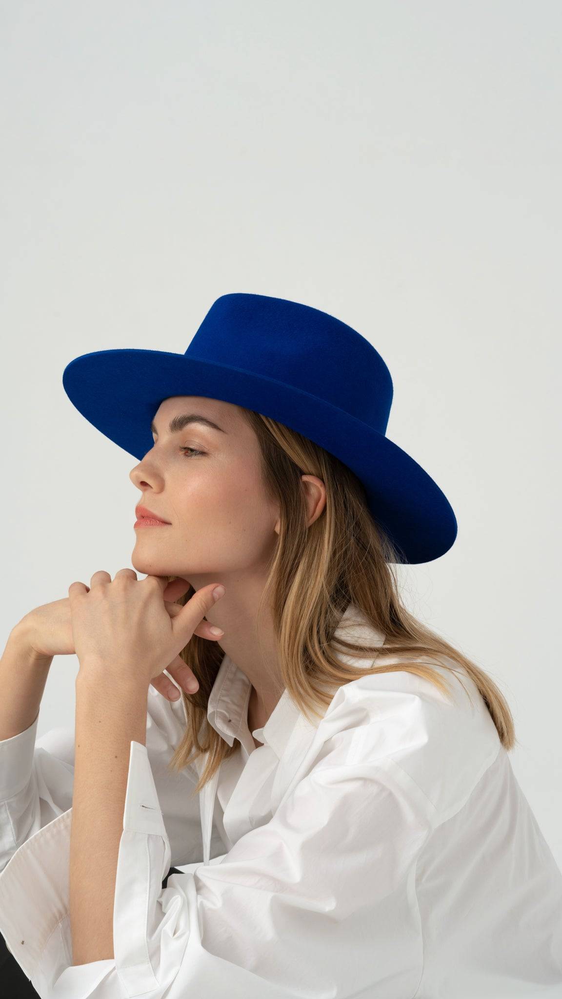 Royal blue fedora hat styled with a white shirt, adding a bold touch to a classic look. Handcrafted rabbit fur felt for a luxurious finish.