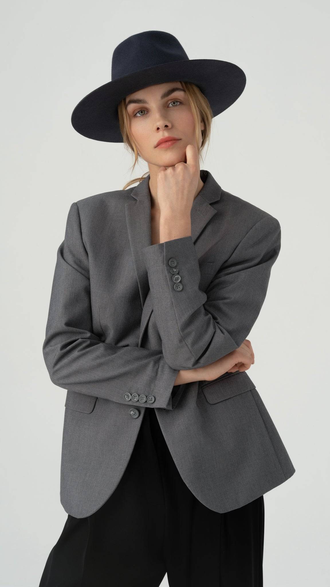 Coal grey fedora hat styled with a grey blazer and black trousers. Handcrafted from premium rabbit fur felt, featuring natural leather strings for a timeless, elegant look.
