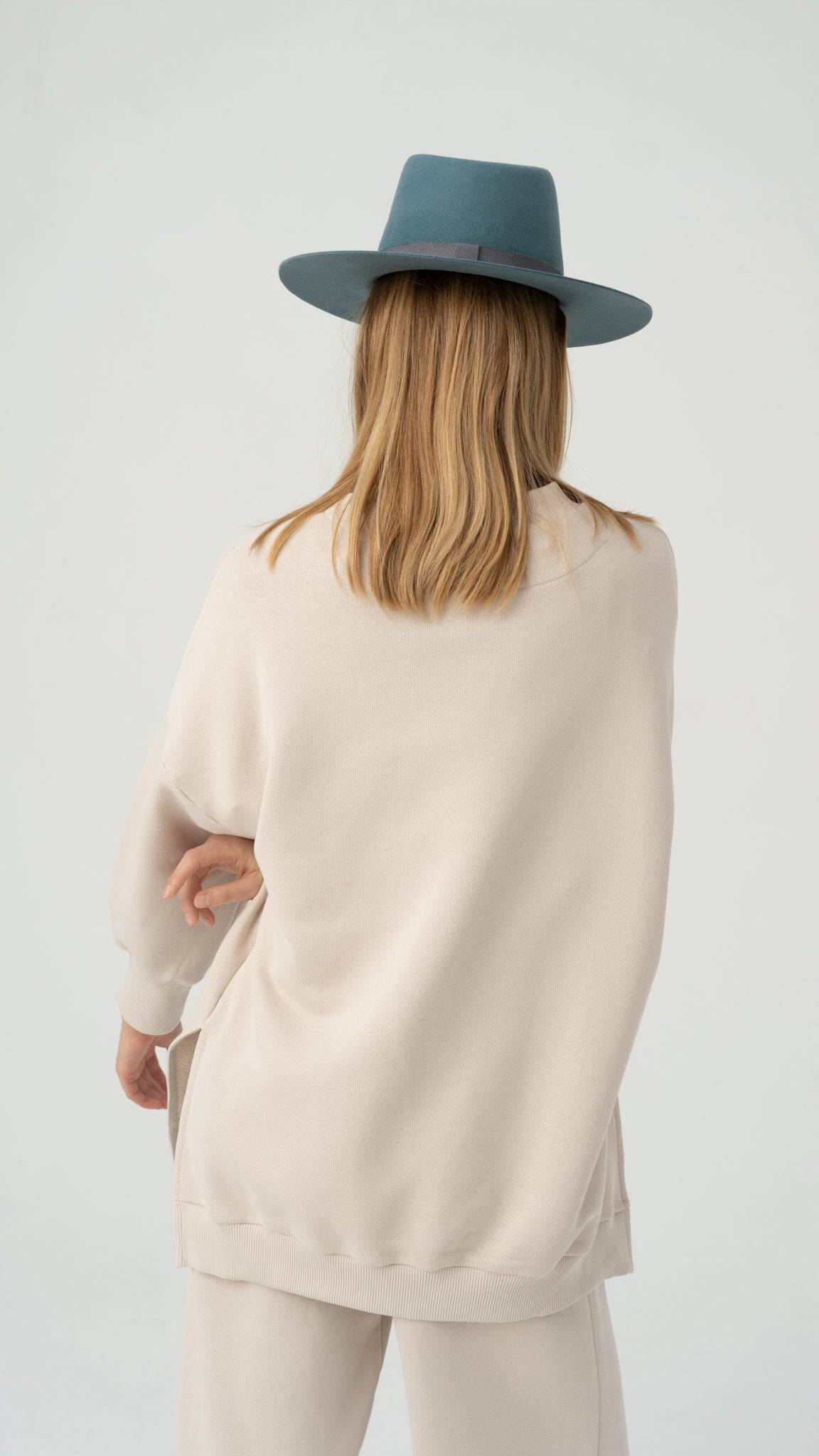 Back view of a teal fedora hat, handcrafted from rabbit fur felt. A stylish and versatile accessory for a sophisticated look.