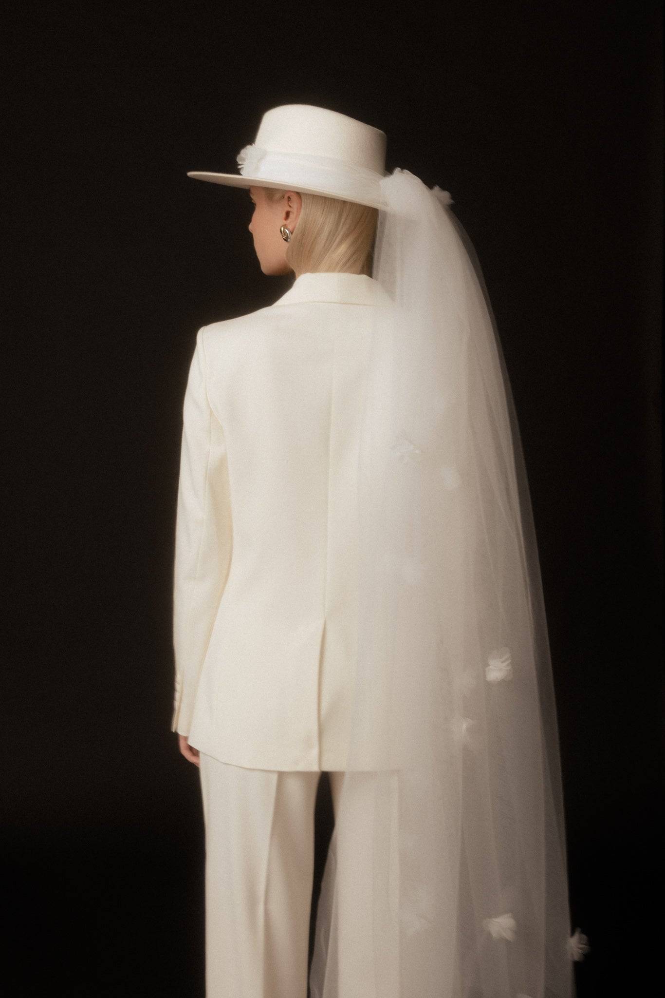 Back view of a bridal fedora hat with a flowing removable veil, designed with jasmine flowers. A unique and stylish wedding headpiece.