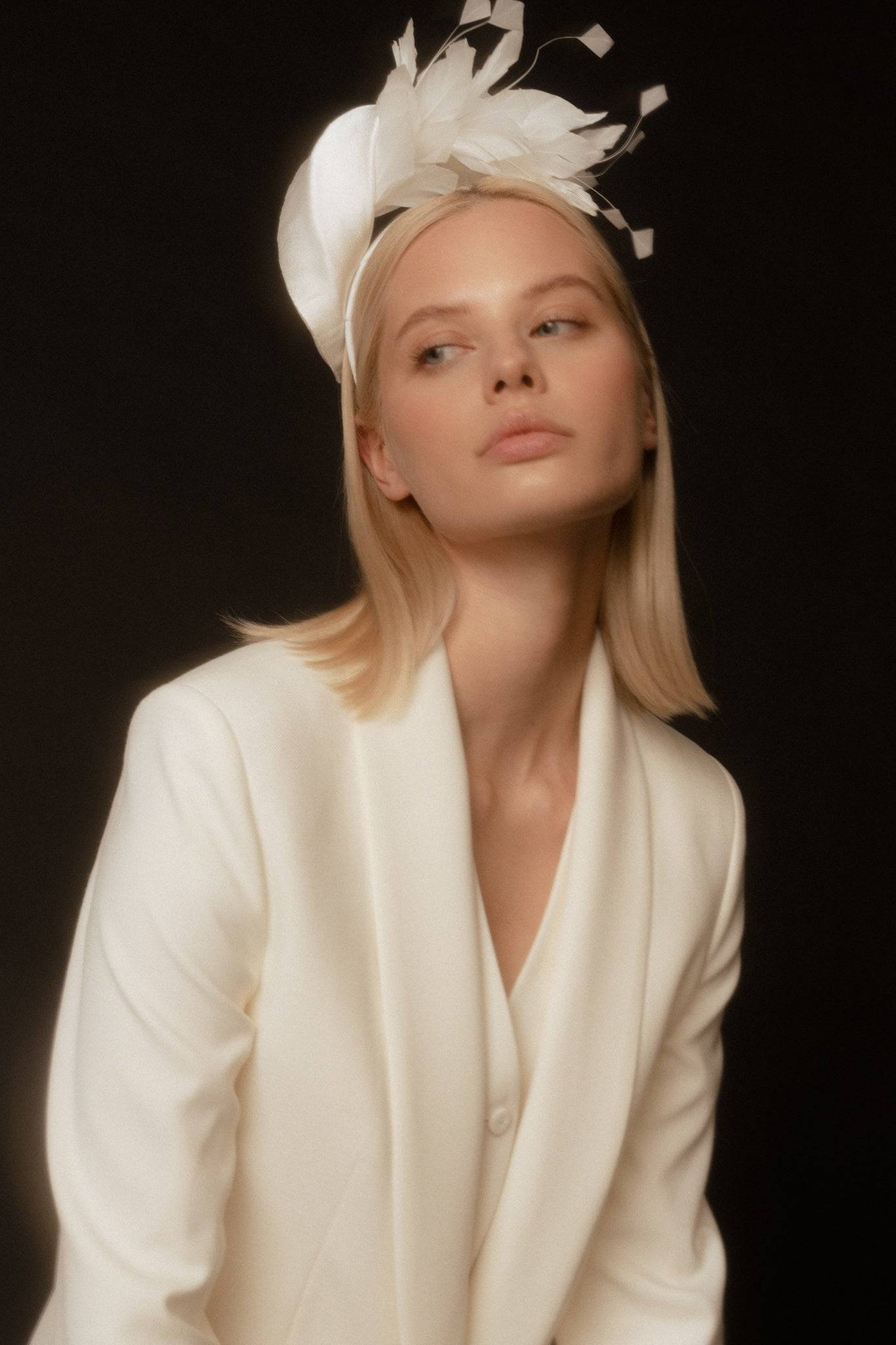 Minimalistic bridal silk headband with handcrafted feathers and crystal embellishments. A modern couture hairpiece for an elegant wedding look.
