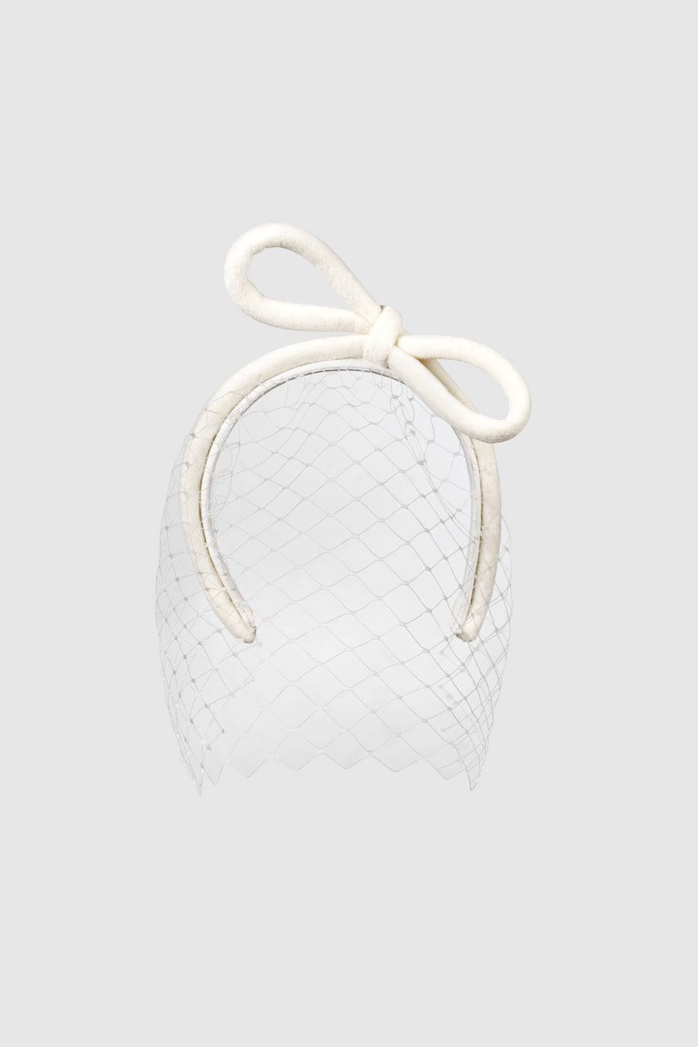 Bridal ivory veiled headband featuring an oversized bow and delicate net veil for a vintage-inspired look. Perfect for weddings and special occasions.