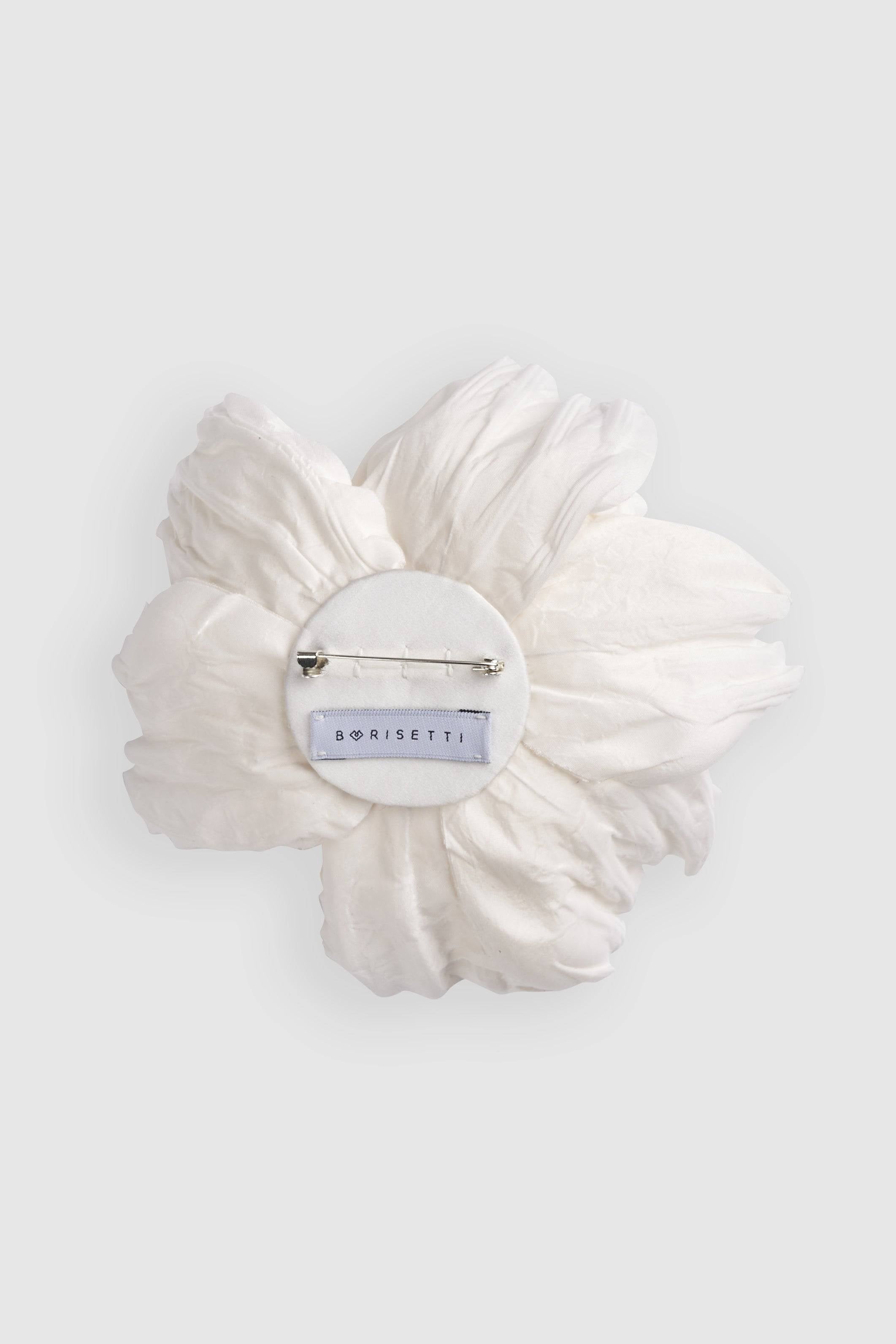 Back view of the silk ivory peony brooch featuring a secure pin clasp and designer label. Ideal for enhancing any outfit with sophistication.