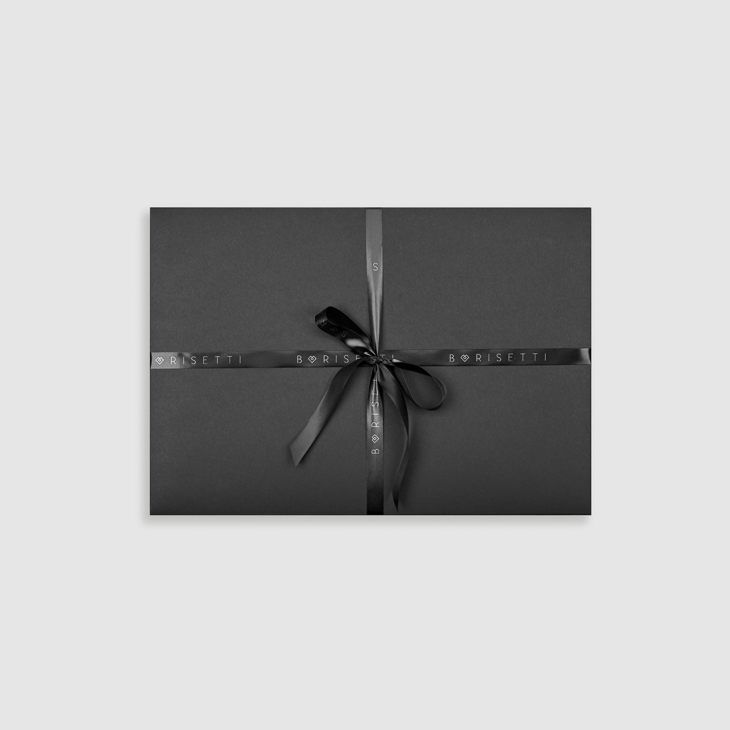 Elegant Borisetti Atelier gift packaging in dark grey with a black ribbon. Perfect for presenting the handmade Merino wool balaclava set.