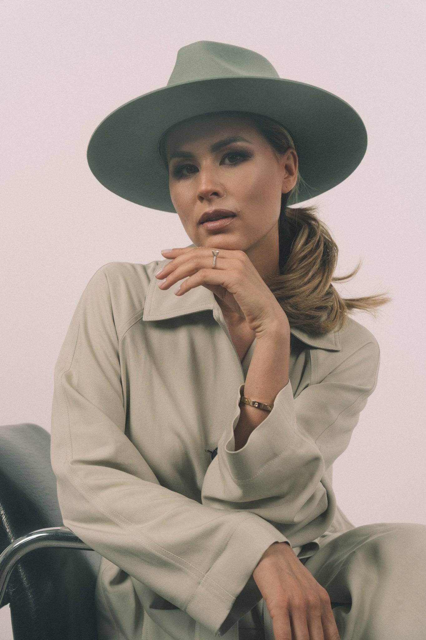 Elegant woman wearing Borisetti green fedora hat. A designer handcrafted rabbit fur felt fedora with a classic dress weight and ribbon.