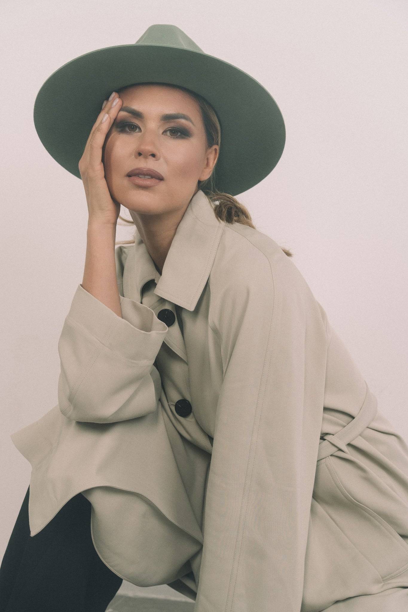 Model posing in Borisetti green fedora hat. A classic dress weight fedora handcrafted from rabbit fur felt with a formal ribbon accent.
