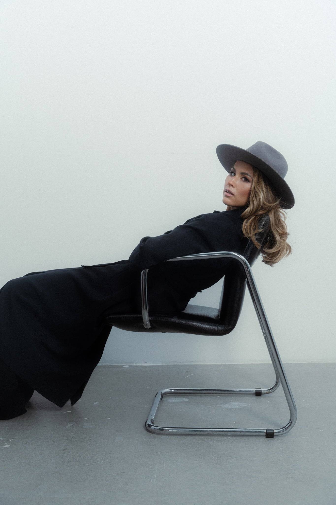 Monogram grey fedora hat paired with a black outfit. A designer accessory crafted from rabbit fur felt for a luxurious and stylish look. Buy now.