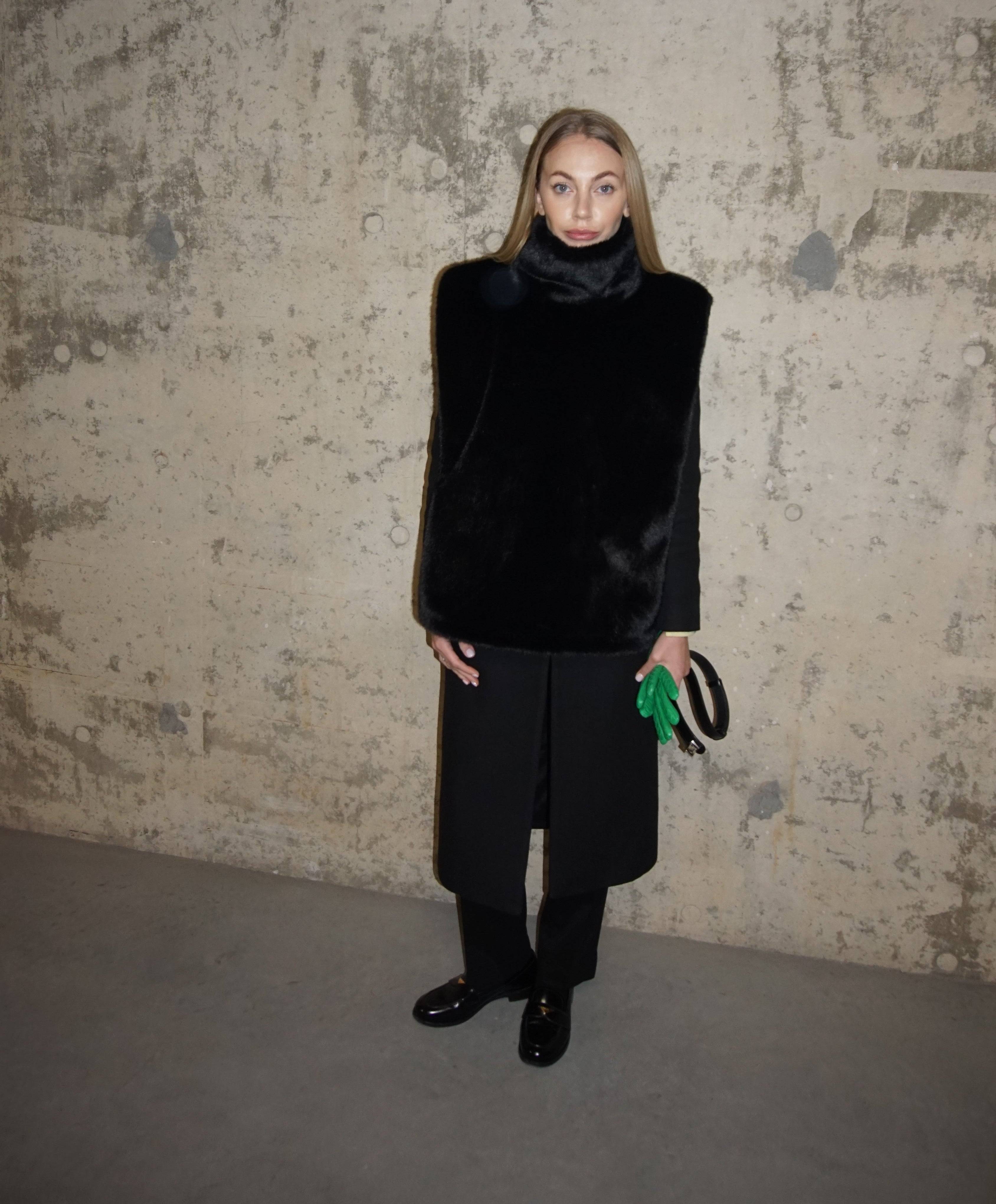 Minimalist black faux fur turtleneck paired with a tailored black coat and trousers. A chic and warm winter layering piece for a sophisticated outfit.