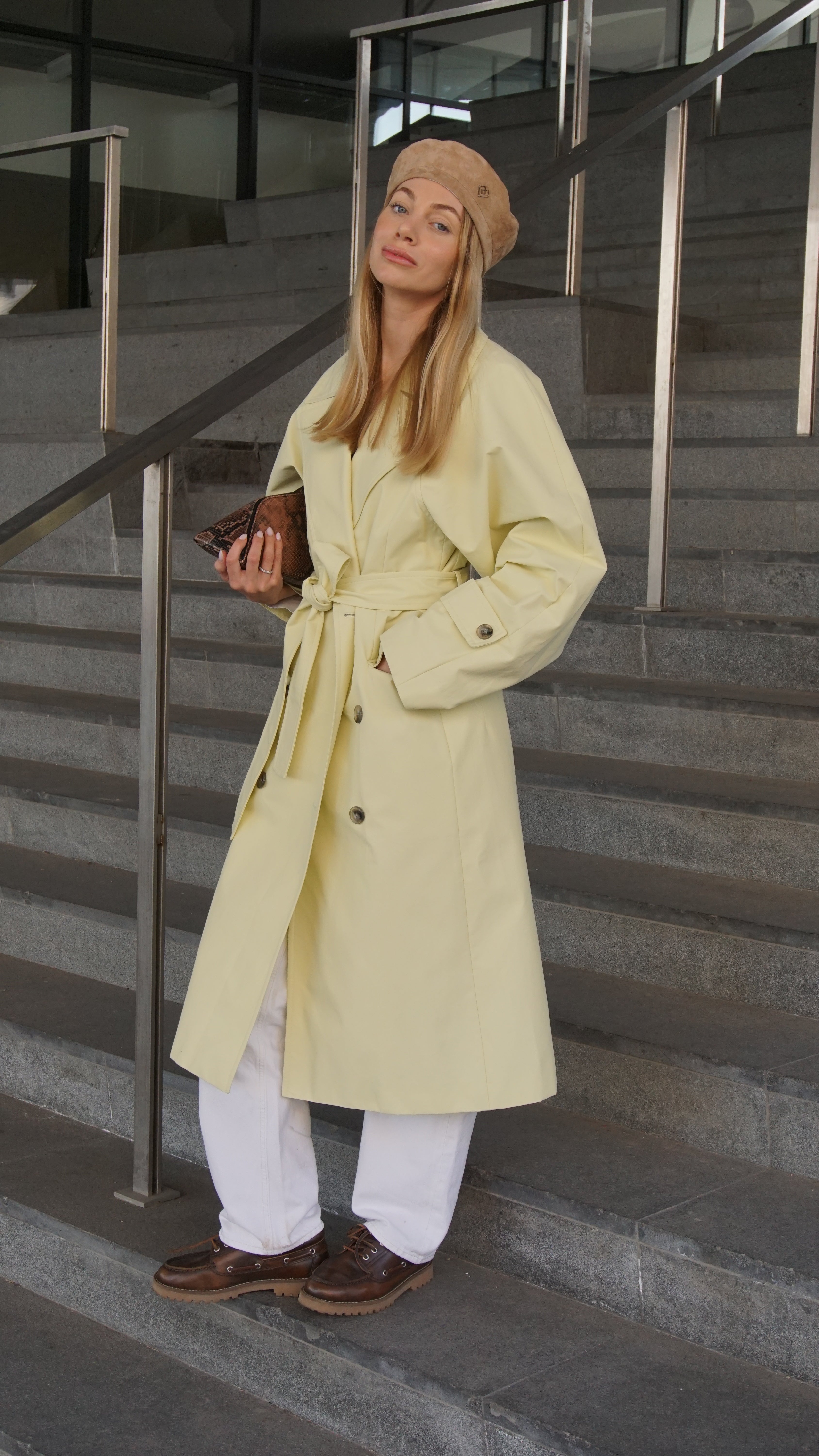Light brown suede leather beret styled with a pastel yellow trench coat and white trousers. A chic Parisian-inspired fashion accessory for elegant looks.