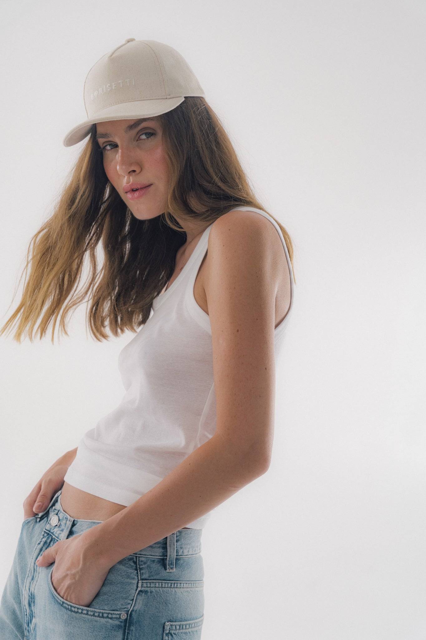 Model wearing Borisetti Denim Baseball Cap in light beige, styled with casual denim and a white tank top for a relaxed, street-style look.