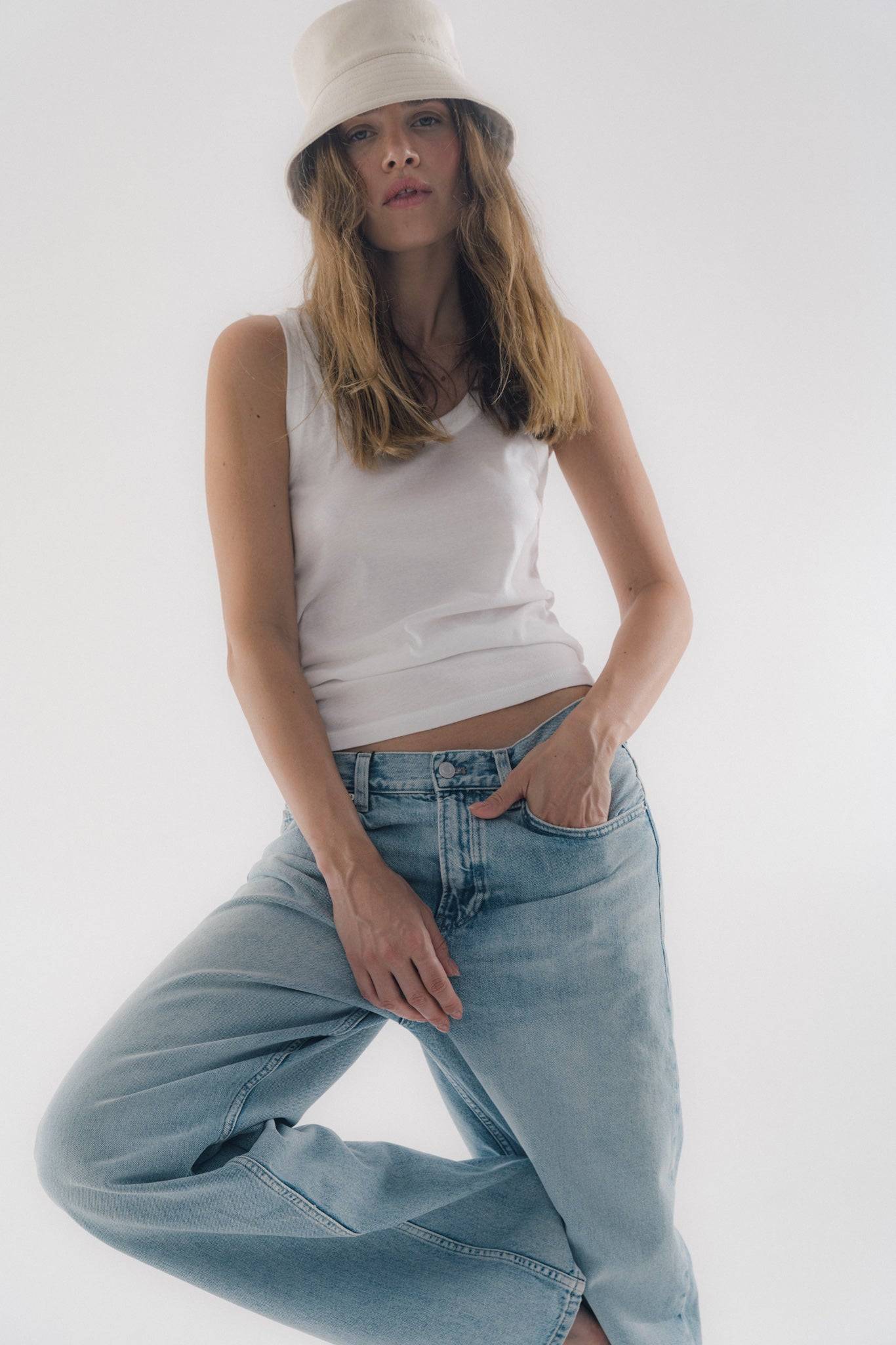 Denim beige bucket hat styled with relaxed-fit jeans and a white tank top. A must-have for everyday fashion and weekend casual looks.
