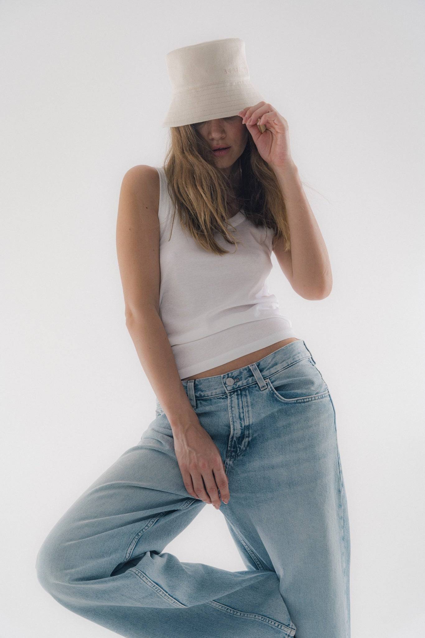 Stylish beige denim bucket hat with a structured design. Perfect for minimalist fashion and high-fashion headwear enthusiasts.