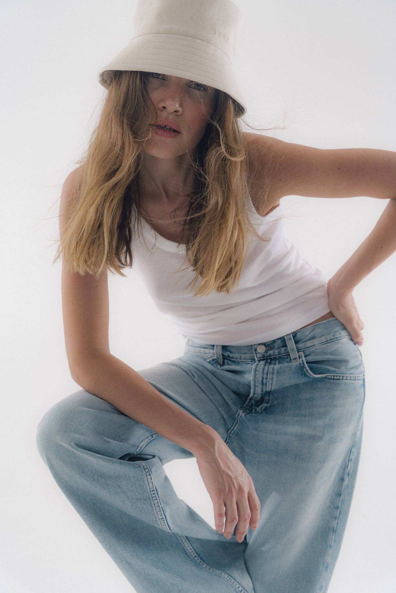 Embroidered beige bucket hat in cotton denim, styled with casual denim jeans. A timeless summer hat for effortless elegance.