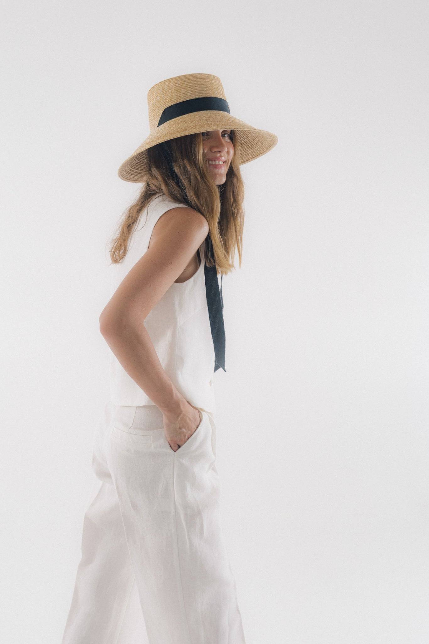 Chic neck tie wide brimmed straw hat with a black ribbon, perfect for summer elegance. Handcrafted Italian design for sun protection and timeless style.