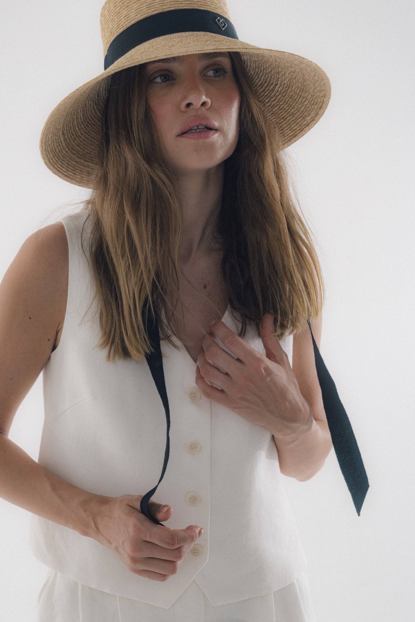 Chic neck tie wide brimmed straw hat with a black ribbon, perfect for summer elegance. Handcrafted Italian design for sun protection and timeless style.