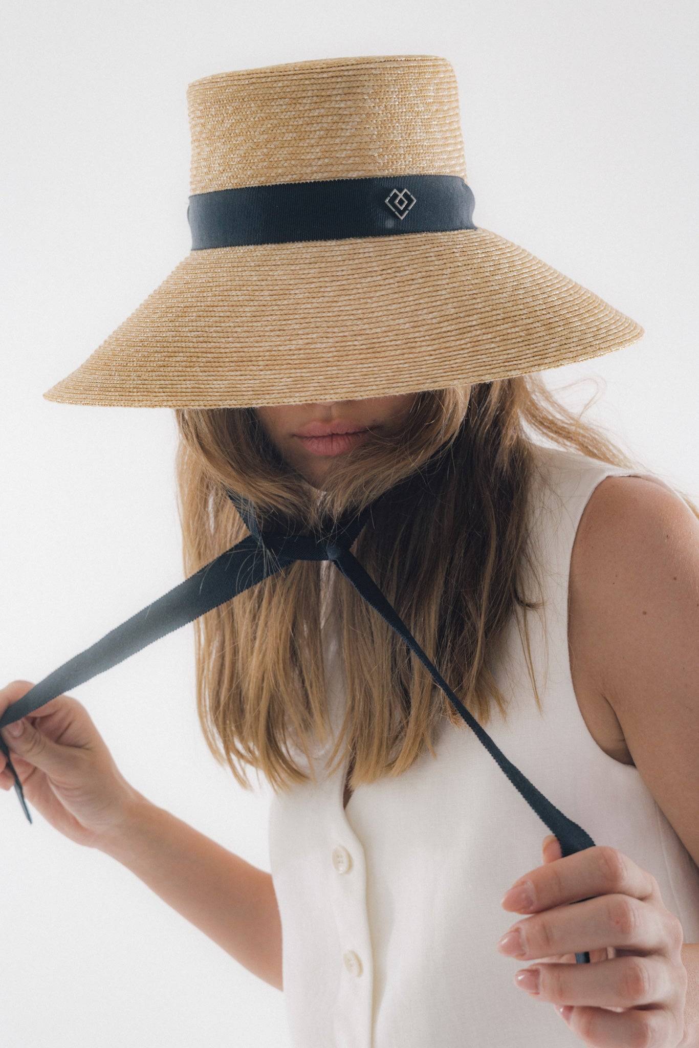 Chic neck tie wide brimmed straw hat with black ribbon, offering elegant sun protection. Perfect for summer vacations and garden parties.