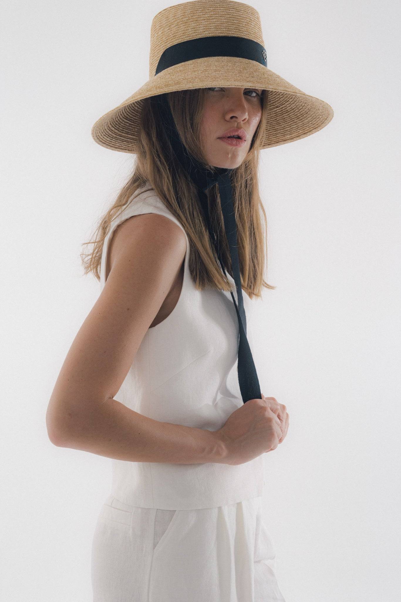 Chic neck tie wide brimmed straw hat with black ribbon, offering elegant sun protection. Perfect for summer vacations, garden parties, and beach outings.