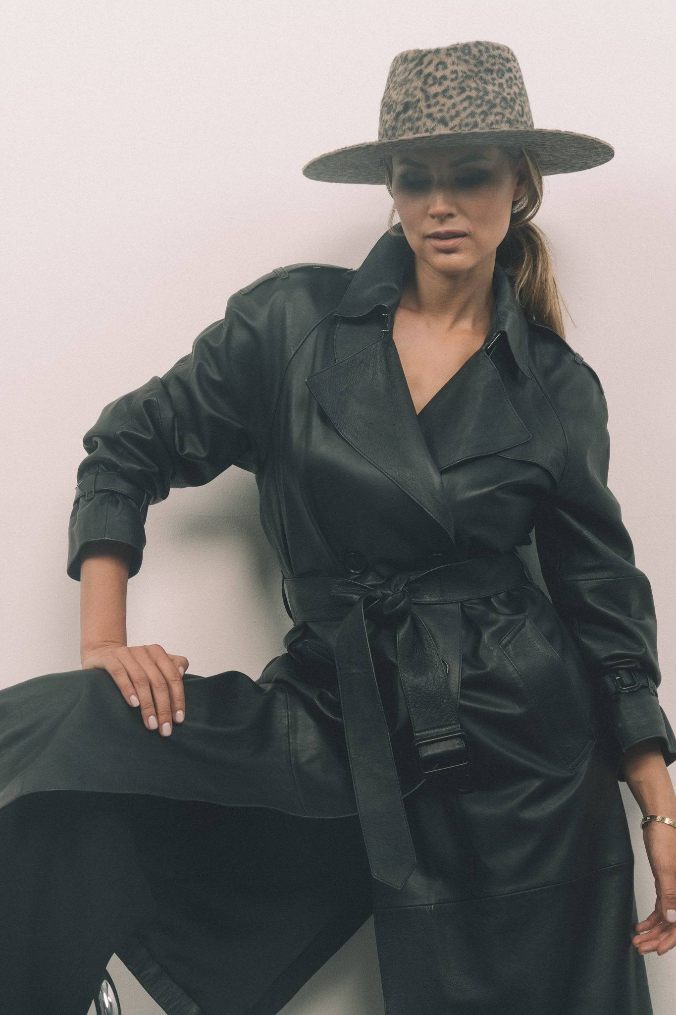 Stylish leopard print fedora hat worn with a belted black leather coat. A bold and sophisticated fashion choice for any season.
