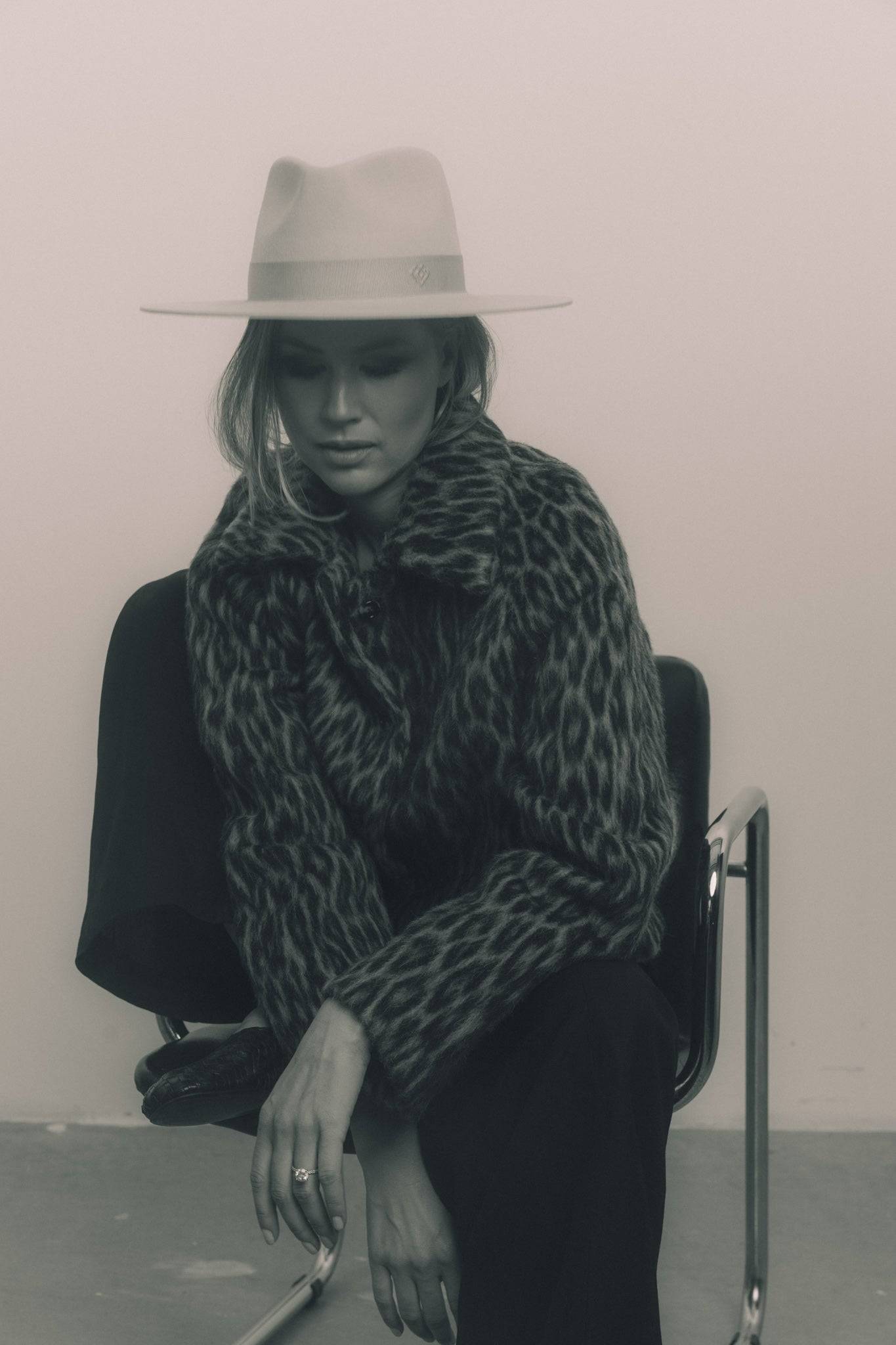 Classic cream fedora hat with a Petersham ribbon, styled with a chic leopard-print coat. A handcrafted rabbit fur felt hat for a sophisticated touch.