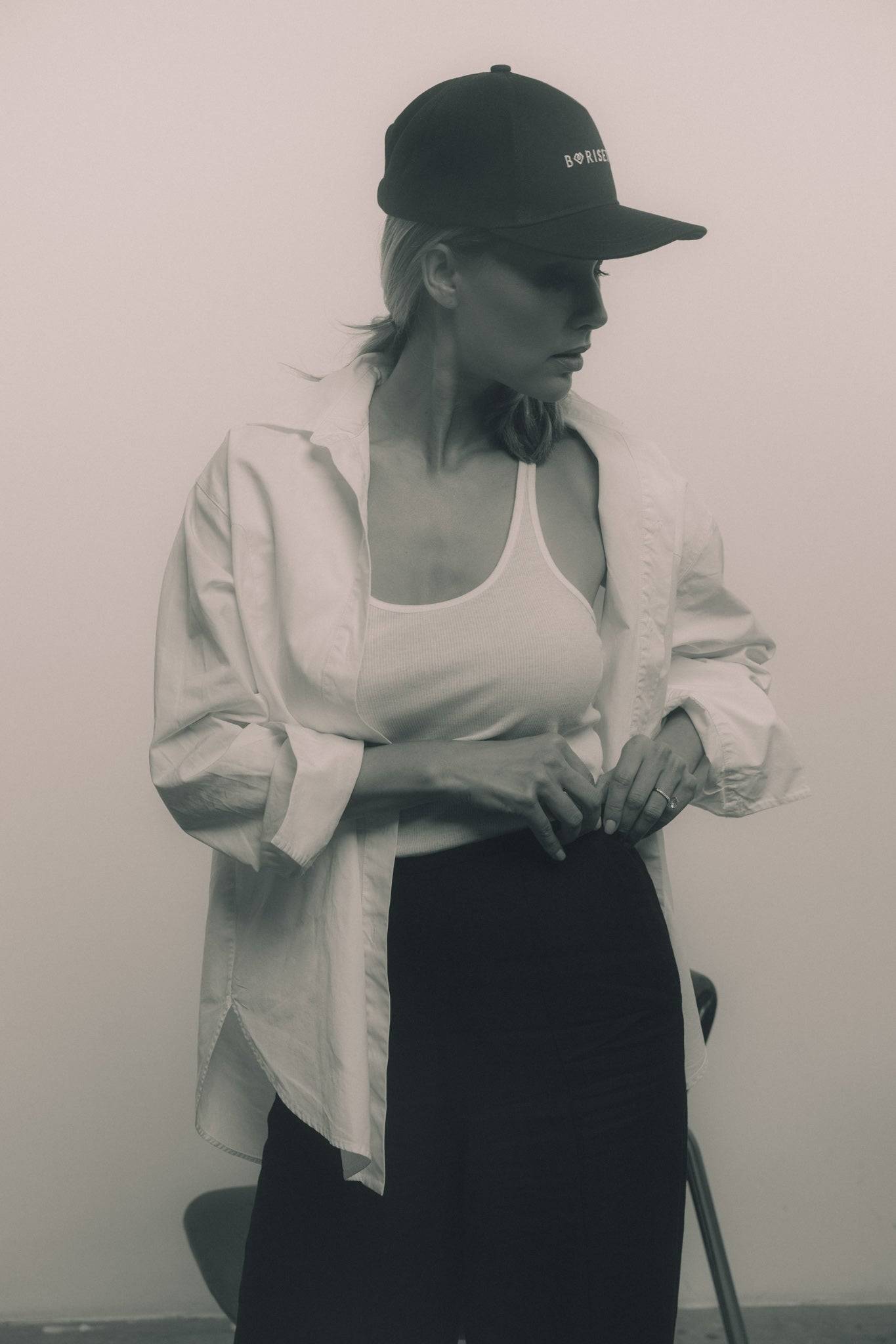 Sport-inspired black denim baseball cap with embroidered Borisetti logo, styled with a white tank top and black pants. A high-fashion accessory for any outfit.