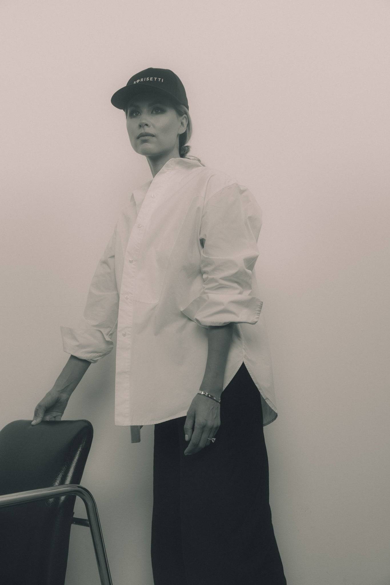Black denim baseball cap with Borisetti branding, worn with a relaxed white shirt and black pants. A timeless street-style accessory for effortless fashion.