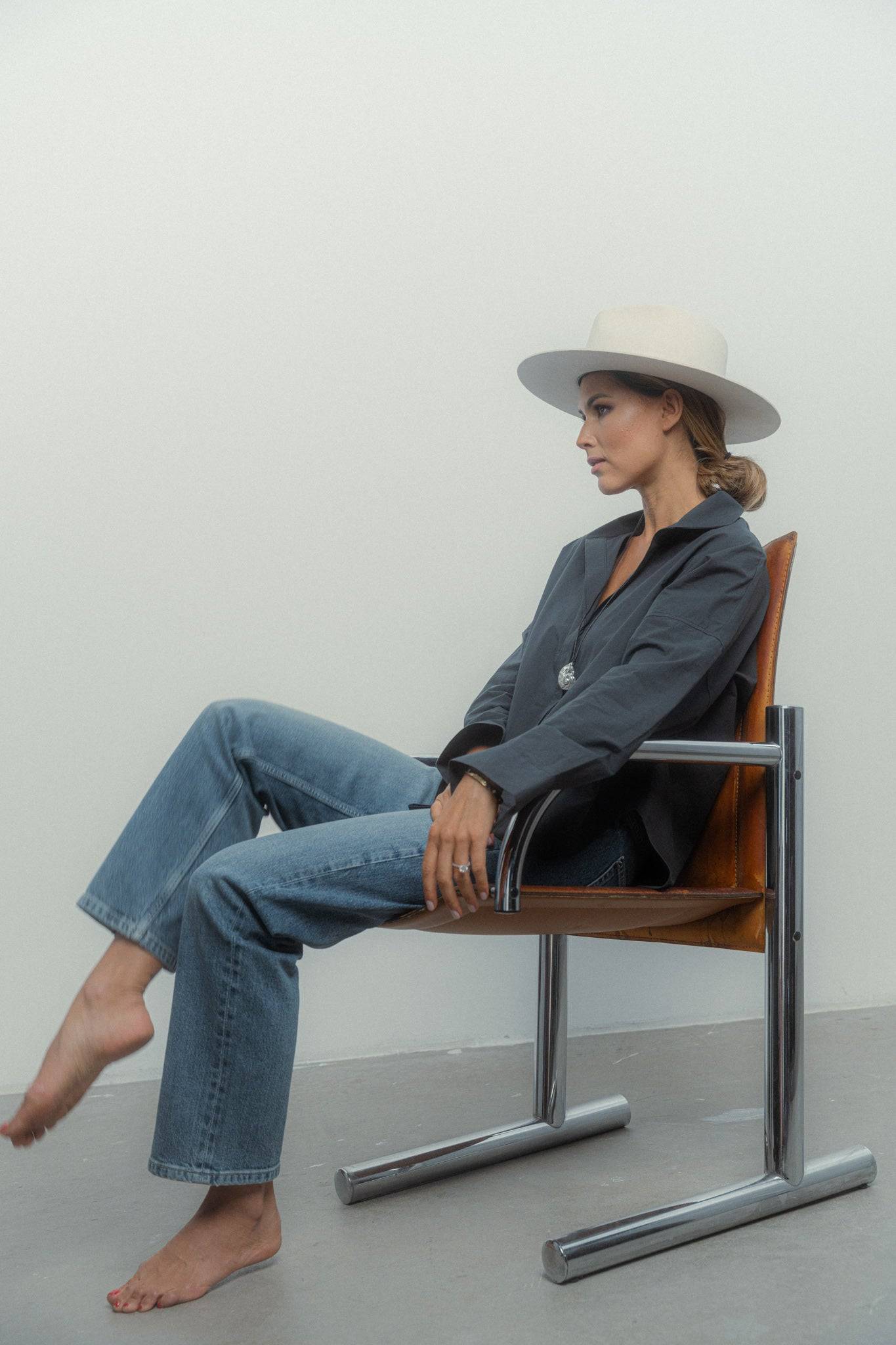 Luxury ivory fedora hat styled with a relaxed black shirt and jeans, creating a modern yet classic fashion ensemble.