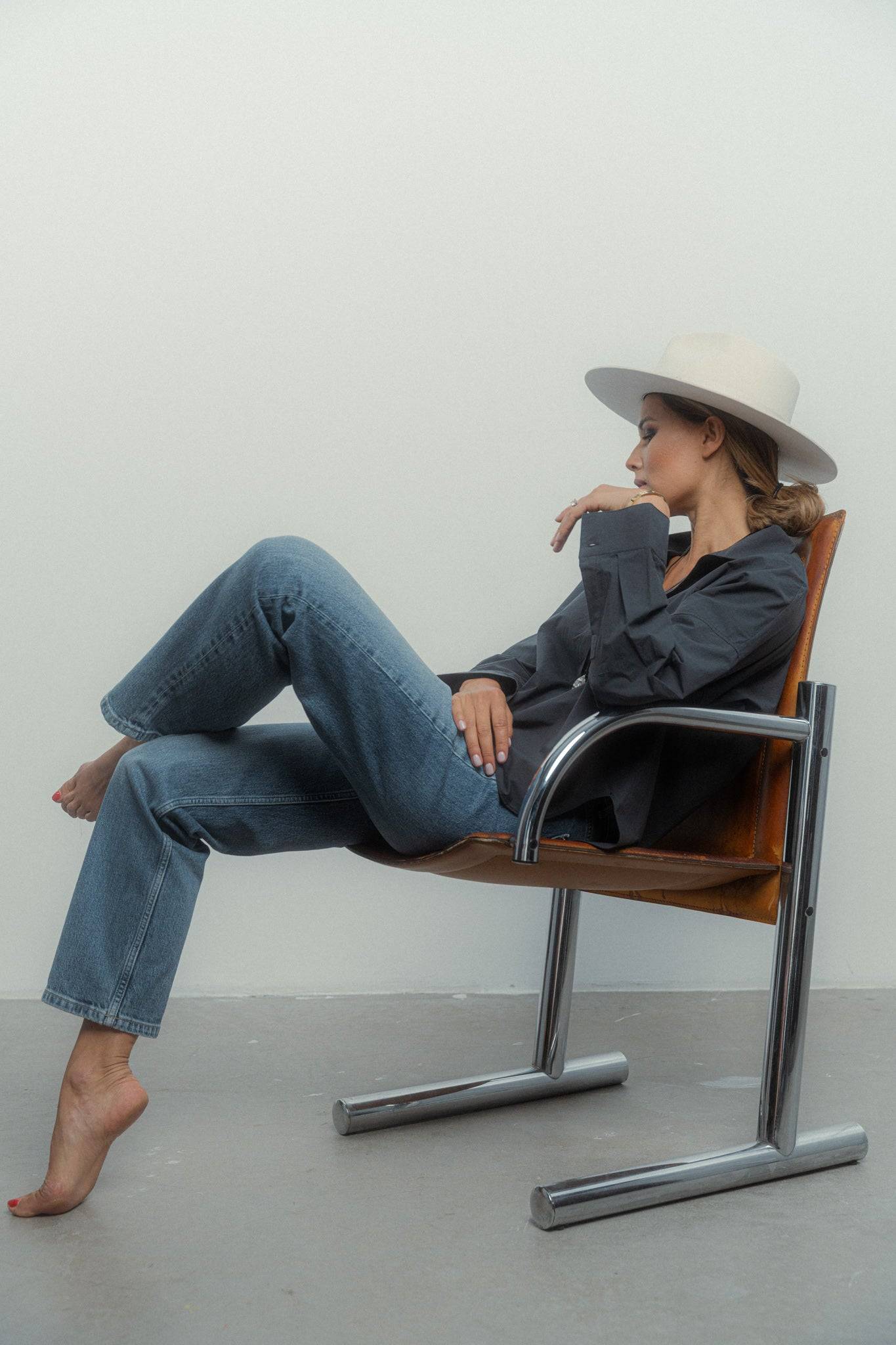 Elegant ivory fedora hat paired with a dark oversized shirt and denim, embodying a chic and effortless fashion statement.