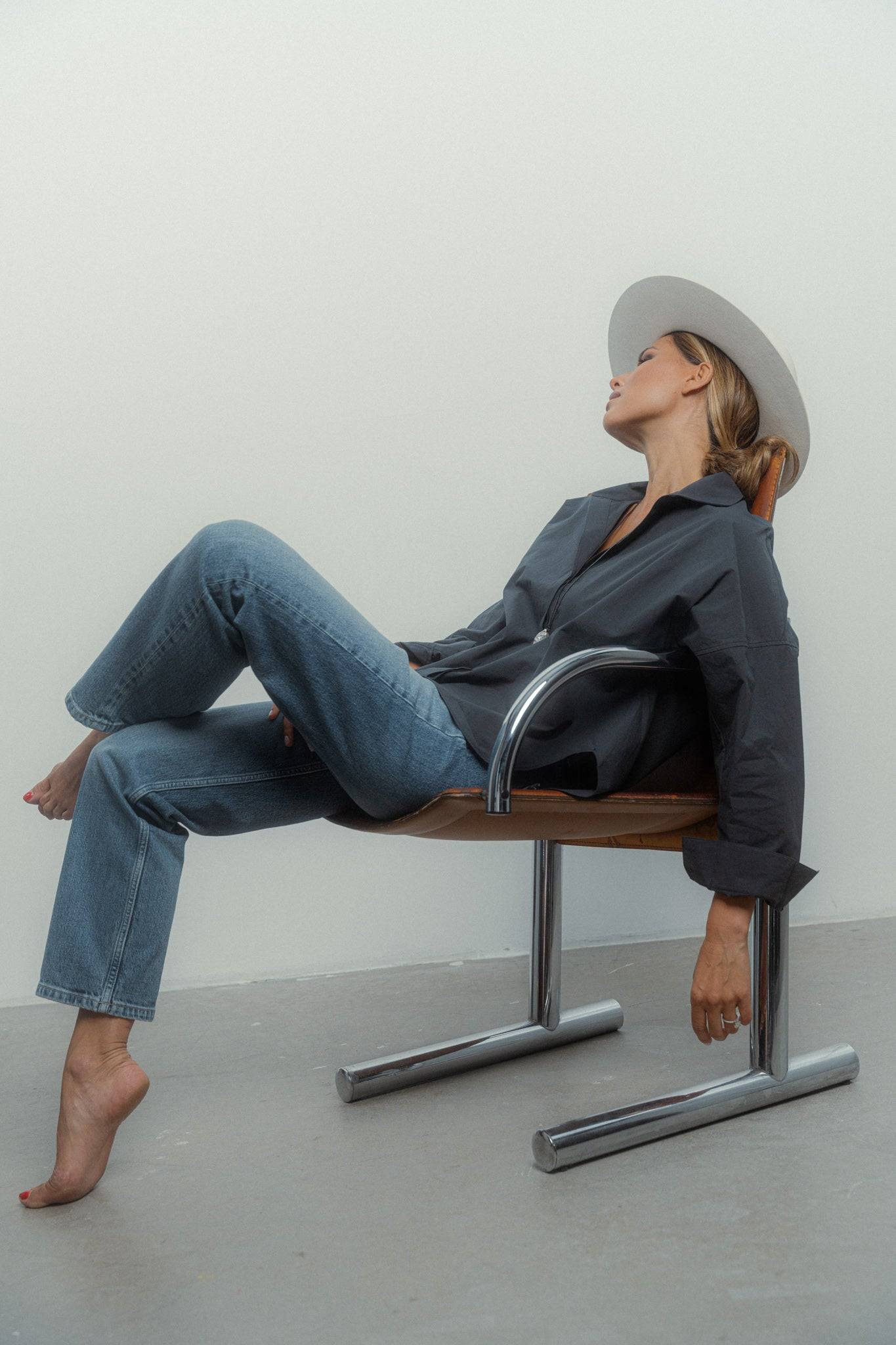 High-fashion ivory fedora hat worn with a dark outfit, highlighting its structured brim and sophisticated appeal.