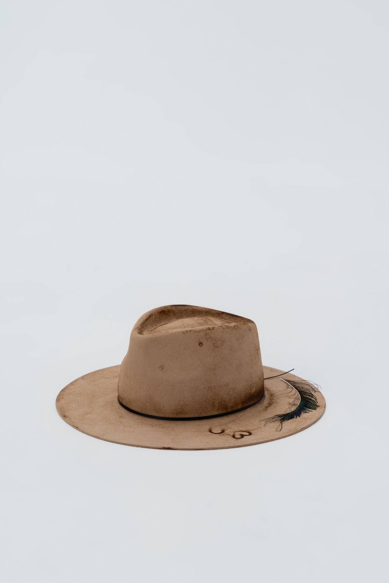 Distressed nude fedora hat with peacock feather and leather trim. Artisan-made rabbit fur felt fedora with a bohemian, fashion-forward design.