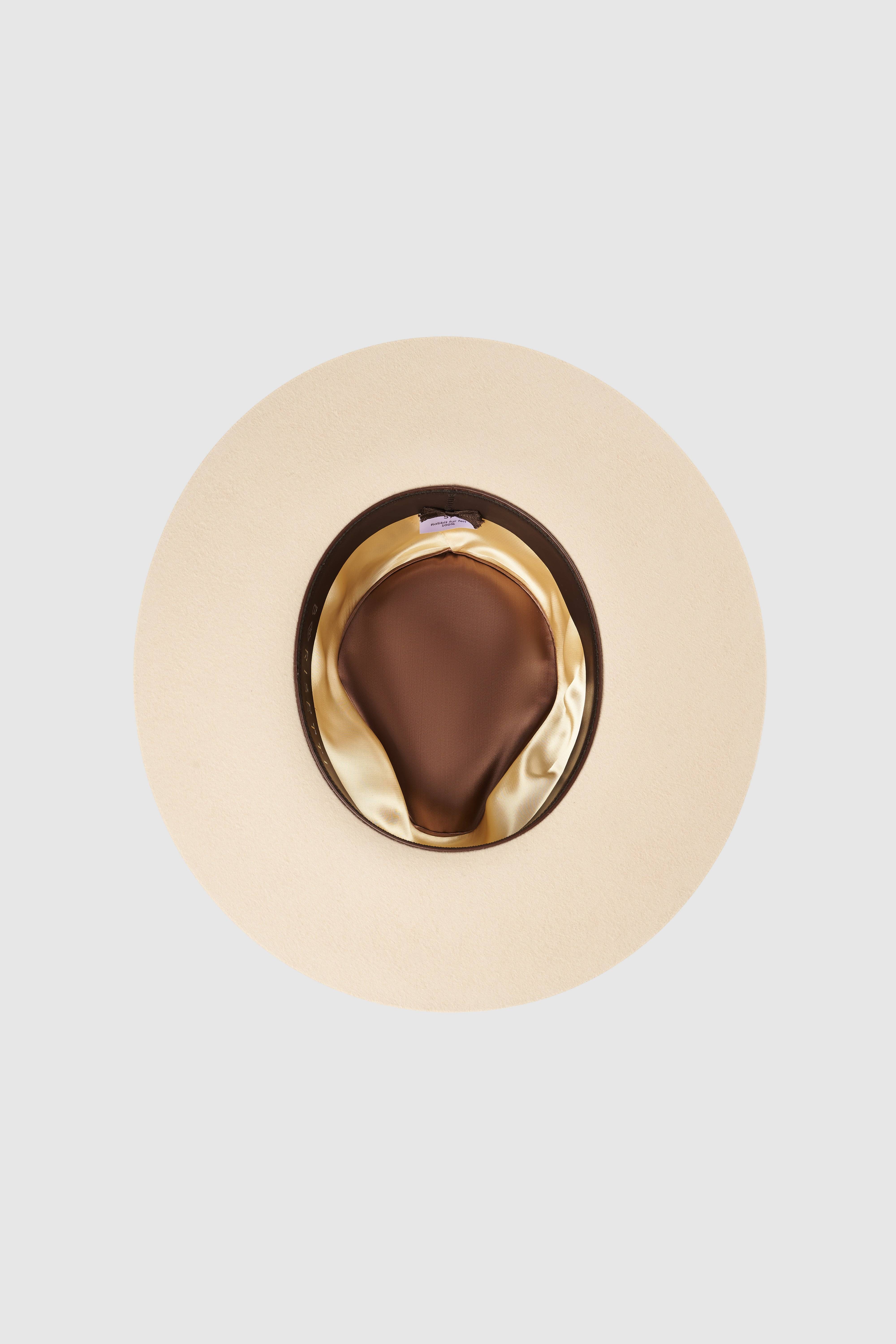 Interior view of a luxury cream fedora hat, showcasing satin lining and leather sweatband. A high-quality handcrafted rabbit fur felt hat for comfort and elegance.