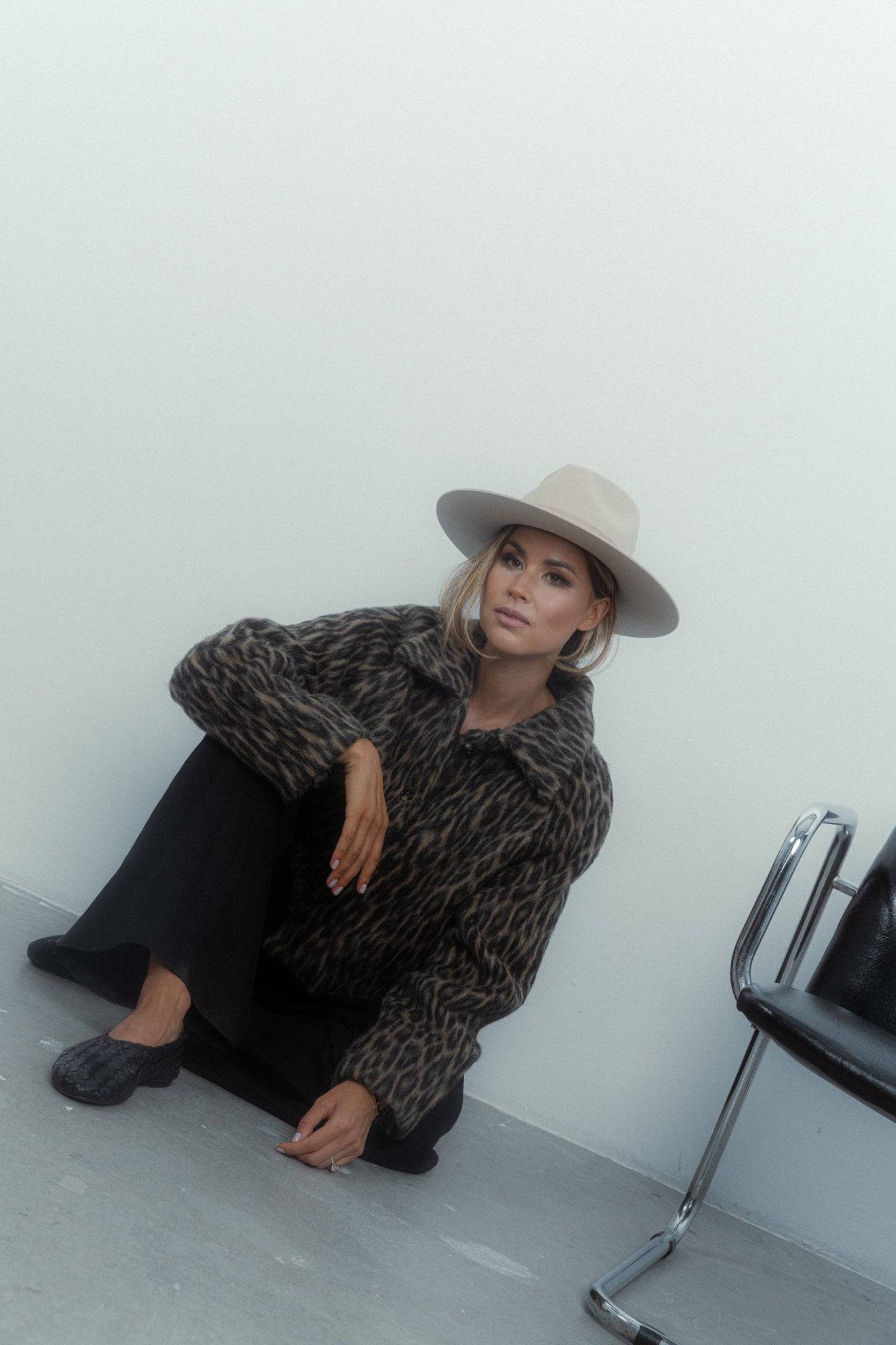 Luxury cream fedora hat paired with a stylish leopard-print coat. A high-fashion statement piece, perfect for formal and casual wear.